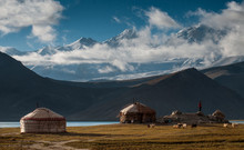 The Yurt Village In Front Of Karakul Lake In Xinjiang Uighur Autonomous Region Of China Is The Highest Lake Of The Pamir Plateau, With Muztagh Ata Peak Of The Kunlun Mountains, In The Background.
