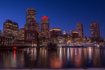Autocollant - Night view of the city, skyscrapers in the lights. Skyscrapers on the shore of the bay, lights reflected in the water, boats at the pier. Boston. USA.
