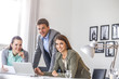© Zdenek - Portrait of smiling young businessman with female colleagues at desk in office