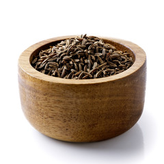 Poster - Dry caraway or cumin seeds in dark wood bowl isolated on white.