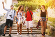 © dusanpetkovic1 - Four cheerful young people going down the big rocky stairs on a vacation in an old town.