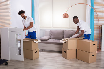 Wall Mural - Movers Unpacking The Cardboard Boxes In The Home