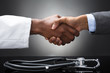 © Andrey Popov - Doctor And Business Man Shaking Hands With Stethoscope On Desk
