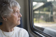 Senior woman looking out of the window on a train journey 
