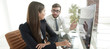 © ASDF - business woman with a colleague sitting at a Desk