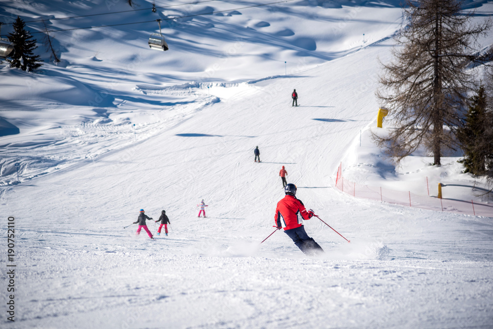 Skiers and ski track on a sunny day in the Alps - obrazy, fototapety, plakaty 