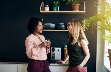 Smiling female office coworkers talking together during a break