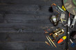 Fishing rods and reels, fishing tackle on black wooden background.