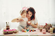 mother and daughter painting eggs for Easter