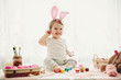 little girl is painting eggs for Easter