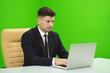 © realstock1 - The man works with the laptop on the green background