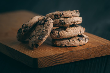 Wall Mural - Chocolate chip cookies on dark old wooden table with place for text., freshly baked. Selective Focus with Copy space