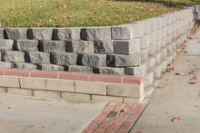 Residential Retaining Wall Featuring A Variety Of Stacked Blocks And Mortared Brick Textures, Horizontal Aspect
