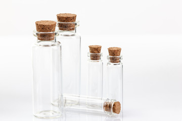 Glass container with cork stopper on white background.