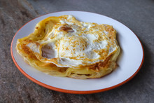 Roti Canai With Egg  On The Plate Over Dining Table