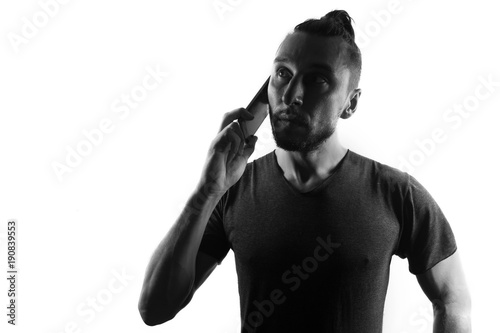 Fotografie, Obraz Male person silhouette use mobile phone,,back lit isolated on white