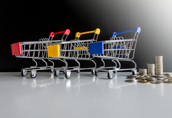 Mini 3 shopping cart with step of coins stacks,Finance and money shopping concept