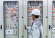 © ETAJOE - Engineer and 115kV control and protection panel at power plant