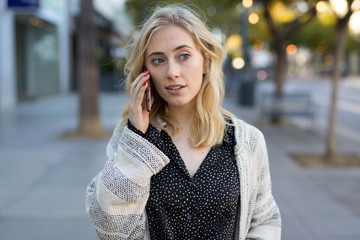 Poster - Young caucasian woman walking talking cell phone