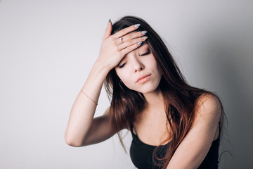 Woman with hard headache holding hands on head on whit background.