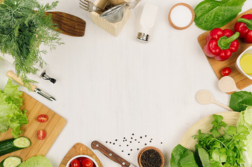 Healthy vegeterian ingredients for spring fresh green salad and kitchenware on white wood board, top view, copy space. Spring vitamin dieting food.