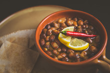A Close Up Color Studio Image Of Egyptian, Arabian, Middle Eastern Traditional Food (Fava Beans With Lemon And Chili Red Paprika) A.K.A (Foul) - Also   Served In Lebanon And Most Of Arabian Countries.