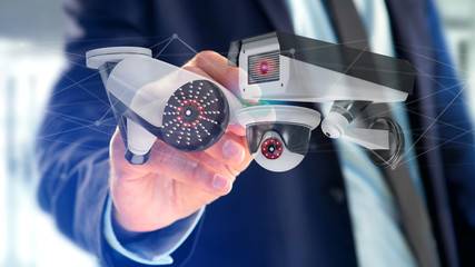 Poster - Businessman holding a Security camera system and network connection - 3d rendering