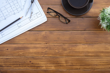 Poster - Flat lay of top view desk work table architect with drawing home plan building and stationary on antique brown wood table in home office includes copyspace for add text or graphic