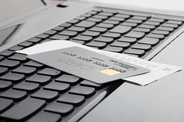 Close up shot of a credit card and a receipt over computer keyboard as a symbol of online shopping