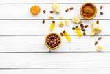 Fototapeta Mapy - Pieces of cocoa butter and cacao powder in bowl for homemade cosmetics. White wooden background top view space for text