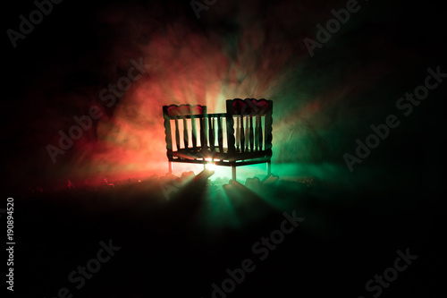 Old Creepy Eerie Wooden Baby Crib In Dark Toned Foggy Background