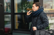 Young man vaping an electronic cigarette outdoor. Casual man smoke vaporizer. Vaping