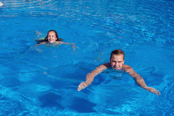 Wall Mural - boy and girl having fun in swimming pool