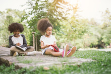 Little Afro Child Girl Reading Book Between Green Spikes Meadow Garden With Friend  Read Education Concept