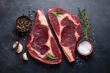 Poster - Raw fresh marbled meat Steak Ribeye Black Angus on black marble background. Beef with spices on a dark stone table. Top view