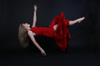 A horizontal image of a floating girl wearing a red dress on a black background. Could be used as a graphic source for a post production of fine art portraits/projects or any other commercial use.