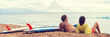 © Maridav - Couple surfers relaxing after surfing on hawaiian beach. Two people lying down on sand beach at sunset next to surfboards after a surf class in Hawaii, panorama banner crop.
