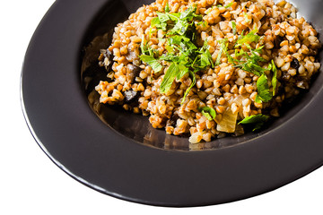 black round deep dish, buckwheat porridge, fresh herbs, parsley isolated on white background