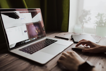 Fototapete - Man freelancer is working using laptop computer at home office. Freelance lifestyle workplace