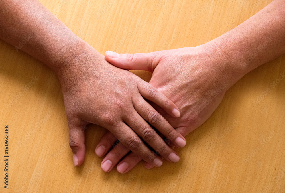 looking down on two hands and lower arms placed ontop of each other ...