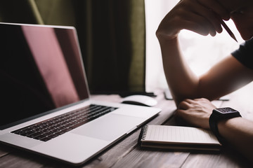 Fototapete - Man is writing on draft notepad and using laptop computer and at home office. Freelance lifestyle workplace