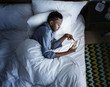 © Rawpixel.com - Man in bed using a digital device in the dark