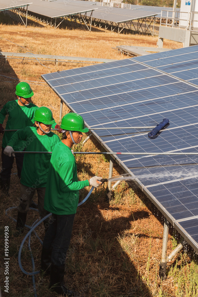 labor working on cleaning solar panel at solar power plant; operation ...