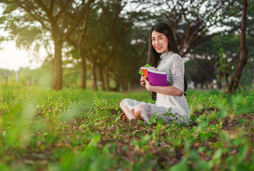 Sticker - young woman holding a book in park