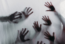 Blurry Scary Silhouettes Of Human Hands Touching Frosted Glass