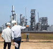 © sittinan - Double exposure of Engineer with safety helmet with oil refinery industry plant background