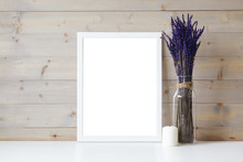 Mother's Day, Women's Day Or Other Suitable Holiday Card In Rectangular Photo Frame With Blank Space For Your Text On White Table With Lavender Flowers Bouquet In Glass Bottle And Paraffin Candle