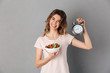 © Drobot Dean - Smiling woman in t-shirt on diet holding plate with vegetables