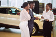 © alfa27 - african Customers signing some important documents at new car showroom