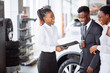 © alfa27 - african couple getting car key from car dealer in showroom and signing contract